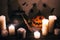 Happy Halloween. Jack o lantern pumpkin with candles, bowl, witch broom and bats, ghosts on background in dark spooky room. fall
