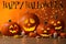 Happy Halloween. Jack o`lanterns, autumn leaves and candles on table against orange background with blurred lights