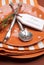 Happy Halloween orange polka dot and stripes plates and napkins dinner table setting. Vertical close up