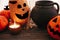 Happy Halloween. Pumpkins with scary faces with witch cauldron, bats, spider and burning candle  on dark wood. Jack o lantern