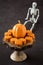 Happy Halloween, small pumpkin cakes, orange ceramic pumpkin on a wooden cake stand, plastic skeleton