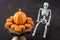 Happy Halloween, small pumpkin cakes, orange ceramic pumpkin on a wooden cake stand, plastic skeleton