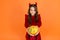 Happy halloween. smiling child in devil horns. kid hold pumpkin vegetable. traditional holiday food and autumn harvest