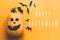 Happy Halloween text, greeting card. Pumpkin with face and black bats, ghost, spider paper decorations on yellow background. Flat