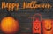 Happy Halloween text on pumpkin with spider and witch hat, Jack o lantern candy bucket and bats on dark background. Handwritten
