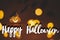 Happy Halloween text sign on glowing jack o lantern pumpkin with spider on dark orange background with lights and flying black