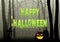 Happy Halloween text on spider web in dark gloomy woods
