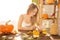 Happy Halloween! Young woman preparing for Halloween in the kitchen. Beautiful woman with pumpkins