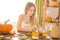 Happy Halloween. Young woman preparing for Halloween in the kitchen. Beautiful woman with pumpkins.