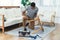 Happy handsome African American man measuring the width between the legs of wood table for renovation. Handyman fixing table using