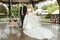 Happy handsome groom and beautiful bride in white dress in wedding arbor at ceremony