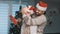 Happy handsome men with santa claus hats hugging in front of the christmas tree. Gift giving and homosexual relationship