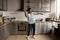 Happy handsome young african american man dancing in kitchen.