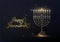 Happy Hannukah greeting cart with gold futuristic menorah and burning candles on black background