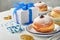 Happy Hanukkah. Hanukkah sweet doughnuts, gift boxes, white candles and chocolate coins on white wooden background. Image and