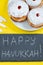 Happy Hanukkah. Jewish dessert Sufganiyot on yellow background. Symbols of religious Judaism holiday. Donuts, candles