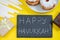 Happy Hanukkah. Jewish dessert Sufganiyot on yellow background. Symbols of religious Judaism holiday. Donuts, candles