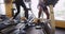 Happy healthy Black and Hispanic couple talking while working out on gym equipment