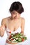 Happy healthy Japanese girl eating green salad