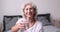 Happy healthy older woman recommending fresh mineral pure water