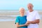 Happy healthy retired elders couple enjoying vacation on the beach