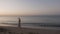 Happy healthy romantic woman walking on the beach wearing dress and straw hat