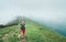 Happy hiker man walking by the cloudy and foggy weather mountain range path with backpack. Active sport backpacking healthy