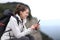 Happy hiker using cell phone in a cliff