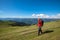 Happy hiker walks along alpine meadow