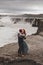 Happy hipster couple kissing in love with view of Iceland Selfoss waterfall
