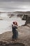 Happy hipster couple kissing in love with view of Iceland Selfoss waterfall