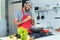 Happy hispanic cook with red apron preparing food at kitchen