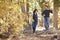 Happy Hispanic couple hold hands hiking together in forest