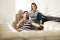 Happy Hispanic Couple Using Smartphones On Couch At Home