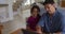 Happy hispanic father and daughter sitting at table looking at laptop