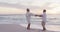 Happy hispanic just married senior couple dancing on beach at sunset