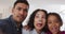 Happy hispanic parents and daughter embracing making funny faces in living room