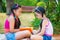 Happy hispanic sisters reading in the park