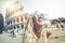 Happy holidays in Rome, smiling young blonde in front of colosseum in Rome in Italy