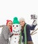 Happy holidays from three best friends. two gorgeous young women taking a selfie with a snowman.