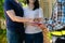 Happy homeowner stand in front of contractor and shake hand, handyman holding clipboard and after checking details before