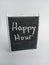 Happy hour written on a chalkboard on a white background