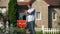 Happy house owner installing for sale signboard in front of building, moving