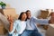 Happy house owners. Young african american couple taking selfie after moving into new home, sitting among carton boxes