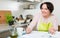 Happy housewife with banking papers in kitchen