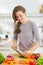 Happy housewife cutting fresh dill in kitchen