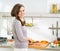 Happy housewife cutting fresh vegetables in kitchen