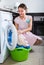 Happy housewife near washing machine