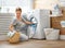 Happy housewife woman in laundry room with washing machine