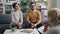 Happy husband and wife talking to psychologist during couple therapy in office